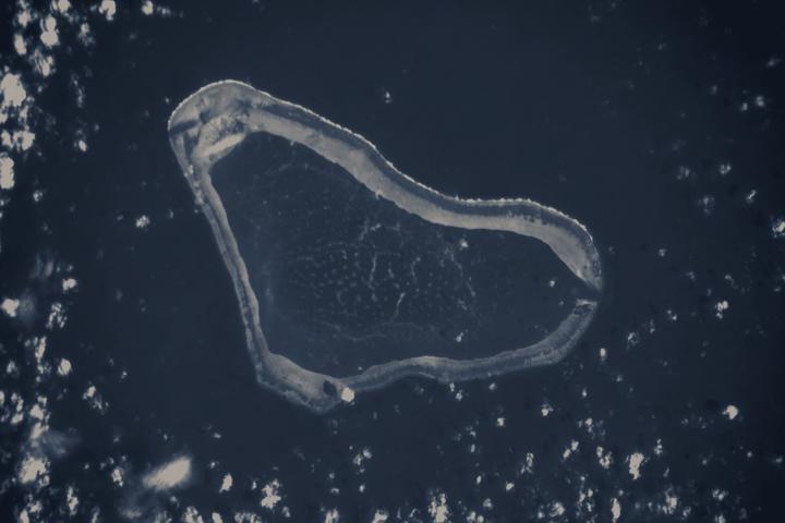 Scarborough Shoal seen from the International Space Station: a triangular coral ring enclosing a turquoise lagoon in the South China Sea